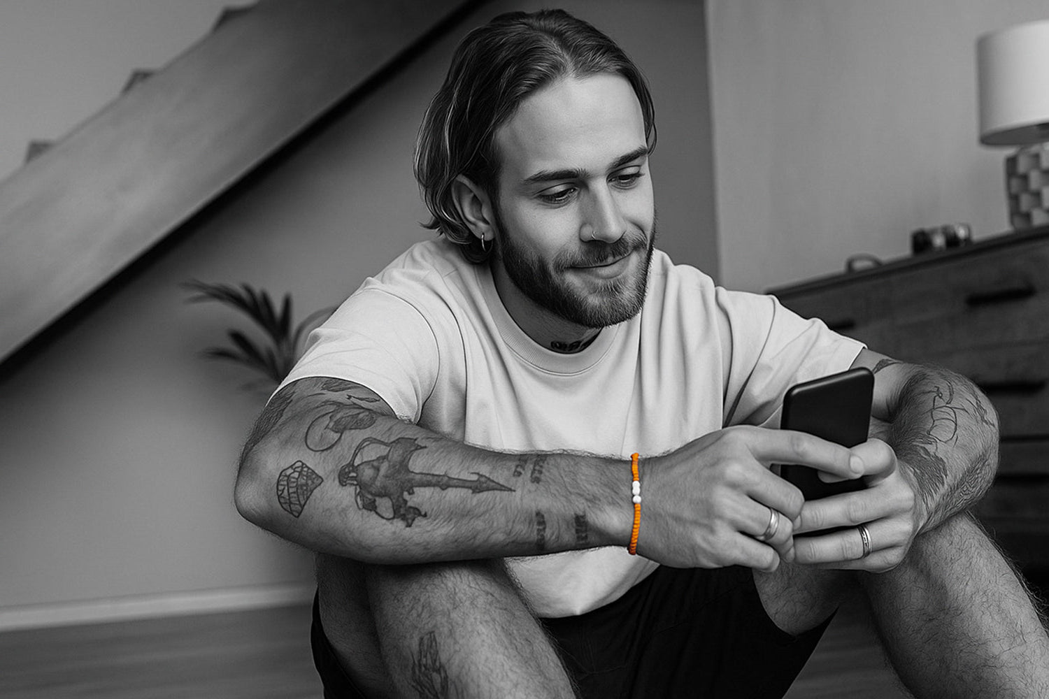 Man sitting and using a smartphone in a room with a neutral color palette